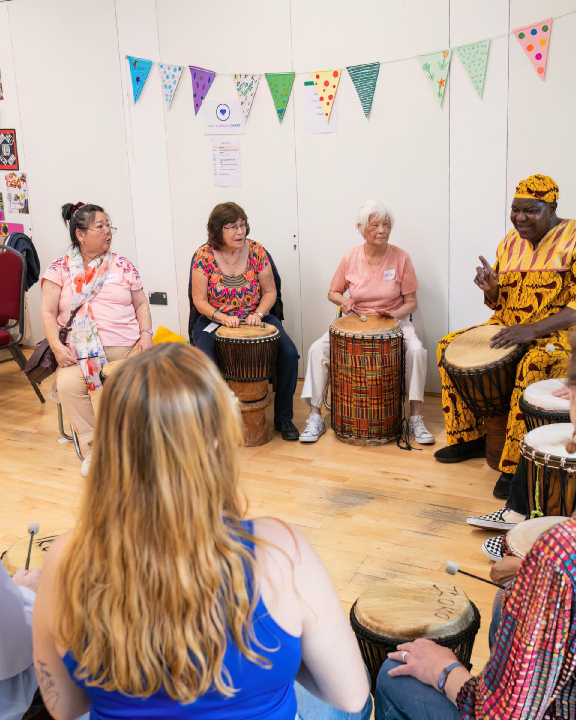 Group of people in a circle banging a drum
