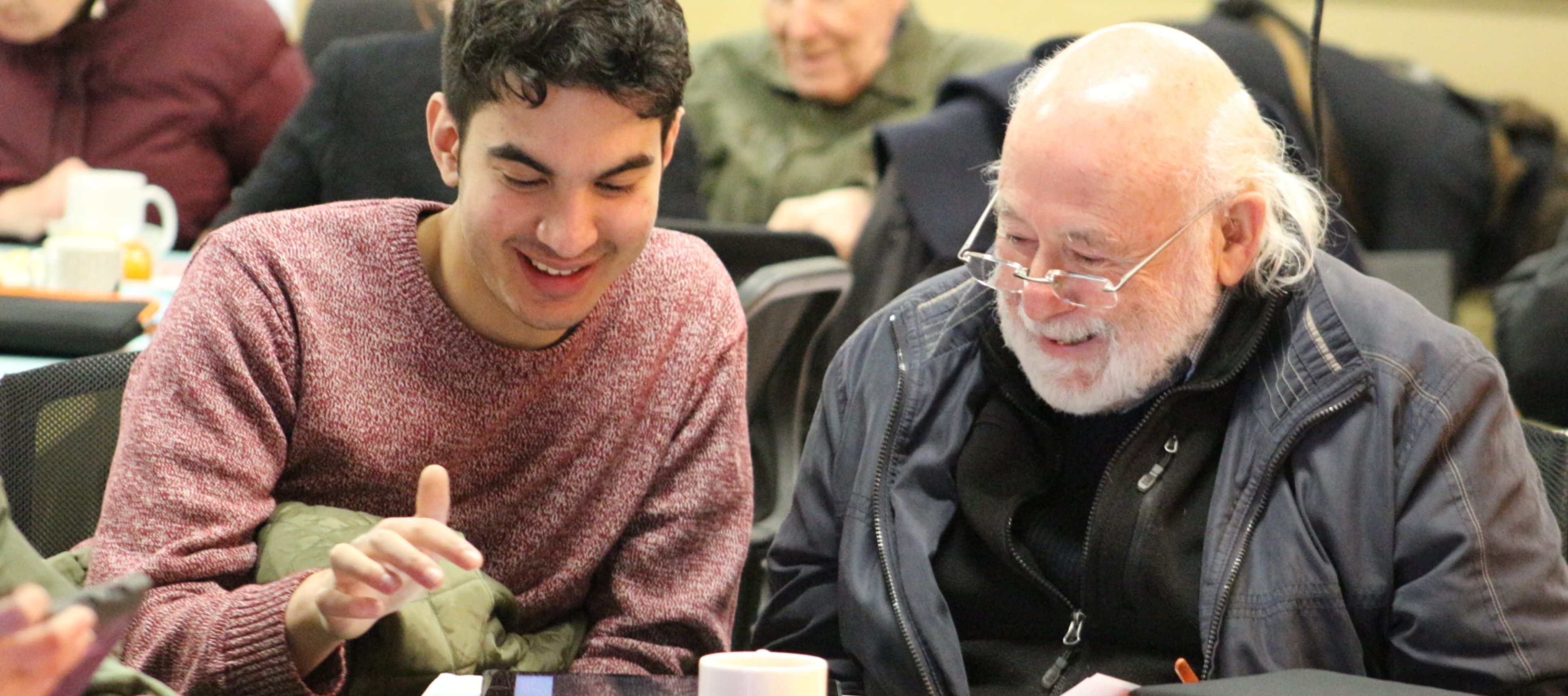 Young man and old man discussing technology